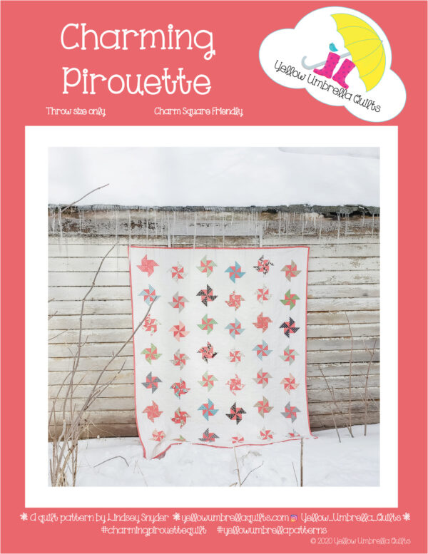 A beautiful pinwheel quilt pattern with vibrant colors from Yellow Umbrella Quilts hanging outside above the snow.